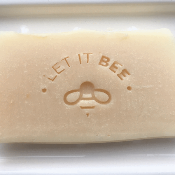 Unwrapped Let It Bee Handmade Soap in white soap dish
